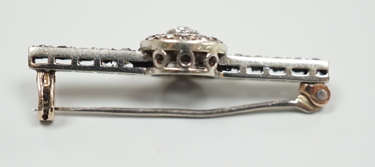 An early 20th century 9ct white metal diamond target cluster set bar brooch, 30mm, gross weight 2.5 grams.